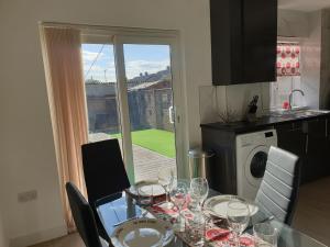 eine Küche mit einem Tisch und Weingläsern darauf in der Unterkunft JDB Dartford 2-Bedroom House in Dartford