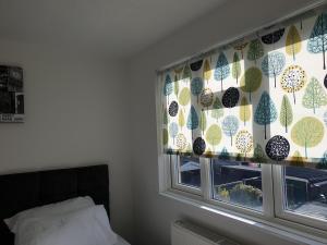 ダートフォードにあるJDB Dartford 2-Bedroom Houseの木の模様のカーテンがかかった窓のある寝室 +5枚の写真