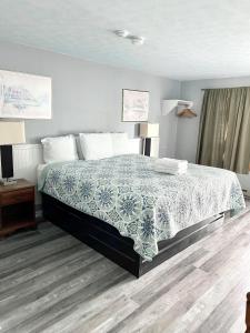 Seacoast Motel في ويلز: غرفة نوم بسرير وبطانية خضراء وبيضاء