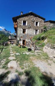 an old stone building with a clock on it at B & B La Guiette in Casteldelfino