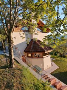 een huis met een bruin dak en een boom bij Baita Agaz in Sovramonte