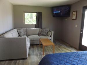ein Wohnzimmer mit einem Sofa und einem TV in der Unterkunft Big Spirit Resort in Spirit Lake