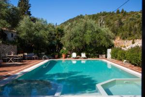 a swimming pool with a mountain in the background at Evridiki's Villas in Agios Nikitas