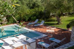 a pool with chairs and a table and a swimming pool at Evridiki's Villas in Agios Nikitas
