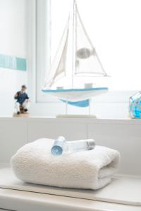 LUXURY BEACHFRONT OUTSTANDING 2 bedroom APARTMENT في إيستبورن: منشفة على منضدة مع قارب شراعي لعبة على نافذة