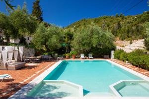 a swimming pool with a mountain in the background at Evridiki's Villas in Agios Nikitas