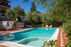 a swimming pool in a yard with trees at Evridiki's Villas in Agios Nikitas