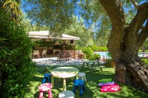 a yard with a table and chairs and a tree at Evridiki's Villas in Agios Nikitas