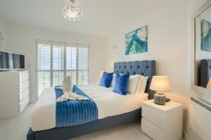 1 dormitorio con cama extragrande y detalles en azul en LUXURY BEACHFRONT OUTSTANDING 2 bedroom APARTMENT en Eastbourne