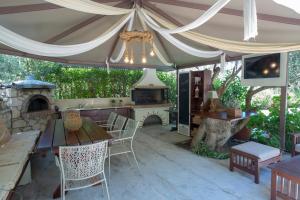 an outdoor patio with a table and a fireplace at Evridiki's Villas in Agios Nikitas