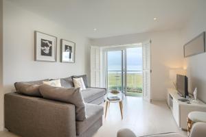 uma sala de estar com um sofá e uma televisão em LUXURY BEACHFRONT OUTSTANDING 2 bedroom APARTMENT em Eastbourne