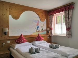 two twin beds in a room with a wall at Rifugio Monti Pallidi in Canazei