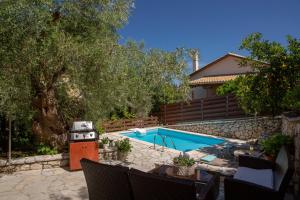 a swimming pool with a grill next to a house at Evridiki's Villas in Agios Nikitas