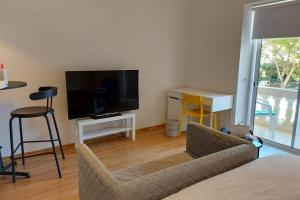 un soggiorno con divano e TV a schermo piatto di Entire guest suite a San Giuliano