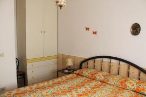 a bedroom with a bed with an orange blanket at Casa Miclara Appartamento -- Limoni in Zanca