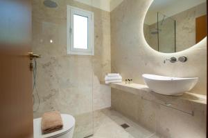 a bathroom with a sink and a mirror at Evridiki's Villas in Agios Nikitas