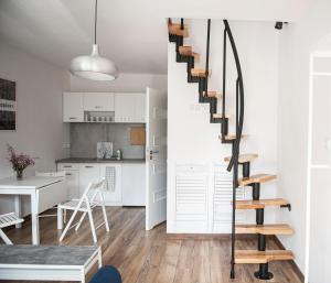 salon i kuchnia ze spiralnymi schodami w obiekcie Domki Wierzbówka w mieście Mielno