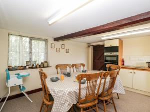 uma cozinha e sala de jantar com mesa e cadeiras em Lawn Farm Cottage em Gloucester