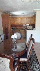 a dining room table with a vase of flowers on it at Sweet Holiday Home in Hadžići