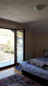 a bedroom with a bed and a large sliding glass door at Sweet Holiday Home in Hadžići