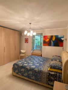 a bedroom with a bed and a chandelier at Pavillon d'Angleterre au cœur de la ville in Menton