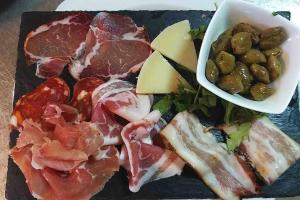 un piatto di carne e verdure e una ciotola di olive di Comodo appartamento in zona centrale e strategica. a Lamezia Terme