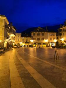 an empty street in a city at night at Torre del Moro in Domodossola +9 photos