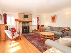 a living room with a couch and a fireplace at Marles Farmhouse in Netherbury