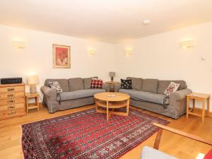 a living room with two couches and a table at Marles Farmhouse in Netherbury