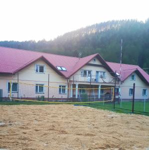 una casa con techos rosados y un campo de tierra en Promenada en Węgierska Górka