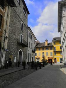 eine Straße in einer Stadt mit gelben und weißen Gebäuden in der Unterkunft Torre del Moro in Domodossola