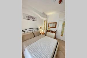 a bedroom with a white bed and a table at San Pietro Loft - appartamento in pieno Centro in Fondi