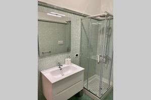 La salle de bains est pourvue d'un lavabo et d'une douche en verre. dans l'établissement San Pietro Loft - appartamento in pieno Centro, à Fondi