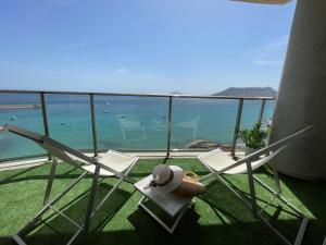 a balcony with two chairs and a view of the ocean at CLP- Primera linea vistas piscina y parking in Calpe