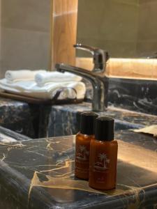 two bottles of shampoo sitting on a counter next to a sink at منتجع ويستن Westin Chalet in Taif