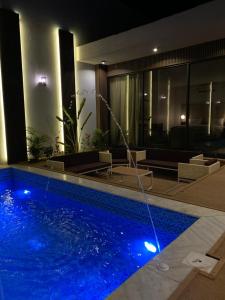 una piscina en una casa por la noche en منتجع ويستن Westin Chalet en Taif