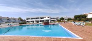 阿爾馬桑－德佩拉的住宿－8 1 Figueirinhas - Casas & Papéis，一座带椅子的大型游泳池和一座建筑
