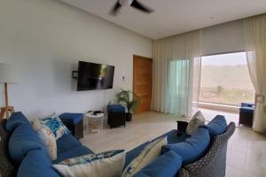 a living room with a blue couch and a tv at Samán Residences D3 in Las Terrenas