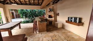 ein Raum mit einer Küche mit Tisch und Herd in der Unterkunft Casa aconchegante e grande no Circuito das Águas Paulista - cem por cento privativa in Amparo