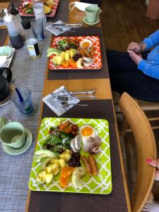 dos mesas largas con platos de comida. en Tom and Rimi's en Kumejima
