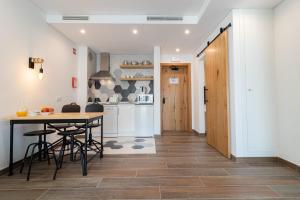 a kitchen and dining room with a table and chairs at Roots Hotel in Faro