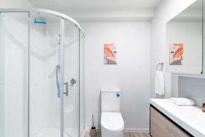 een witte badkamer met een douche en een toilet bij Alpine Loft with Jaw-dropping View! in Queenstown