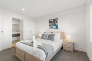 een slaapkamer met een groot bed met witte lakens bij Alpine Loft with Jaw-dropping View! in Queenstown