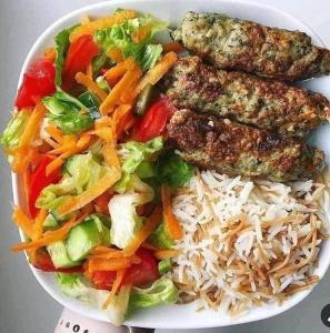 een bord met rijst, vlees en groenten bij Bianki vip villa in Alexandrië