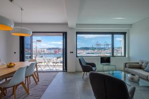 uma sala de estar com uma mesa e cadeiras e um sofá em Nomad's 2Bed Riverside Lisbon em Lisboa
