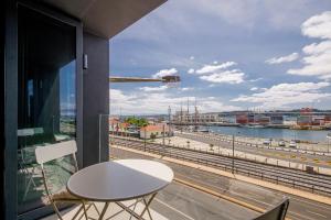 a balcony with a table and a view of a river at Nomad's 2Bed Riverside Lisbon in Lisbon