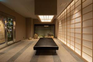 a hallway with a black bench in a building at hotel H2 TRIP&BUSINESS NAGASAKI in Nagasaki