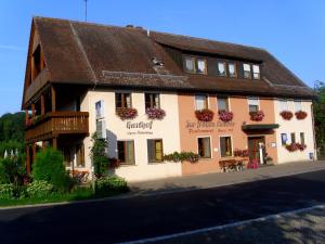 un gran edificio con flores en las ventanas en Gasthof Zur frohen Einkehr, en Reichardsroth