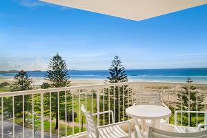 a beach scene with a balcony overlooking the ocean at Meridian Tower Kirra Beach in Gold Coast