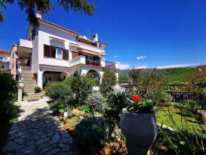 uma casa com um jardim em frente em Apartments Zuppy em Crikvenica